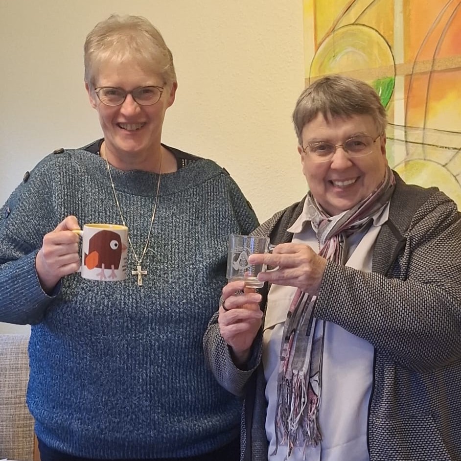 Provinzleiterin Sr. Hilde Bosmans (li) und Provinzleiterin Sr. Petra Egeling (re) freuen sich über die gegenseitigen Gastgeschenke: eine Don Bosco Tasse bzw. ein Teeglas mit der hl. Sr. Maria Troncatti. 